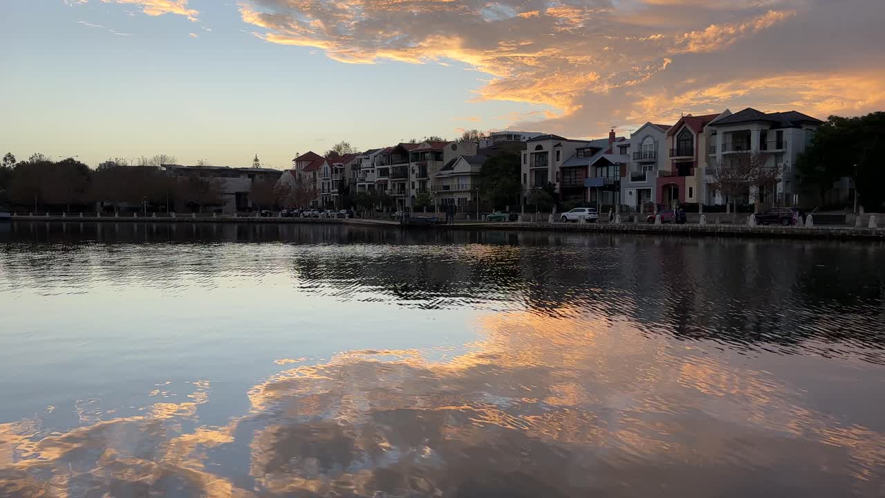 Sunset over a tranquil waterfront town with reflections