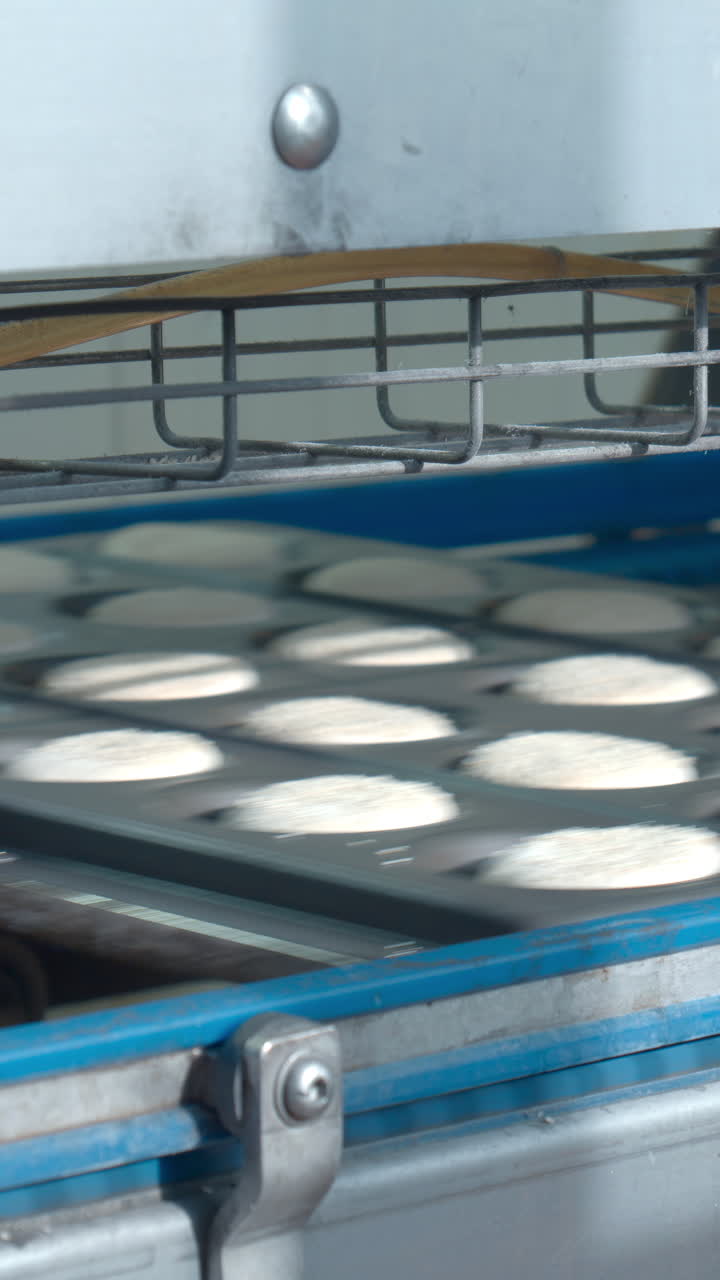 Close-up of Dough Trays Moving on Industrial Bakery Conveyor