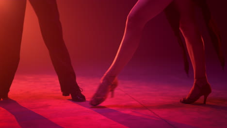 dancers feet exercising movement on stage. dance couple performing indoors.