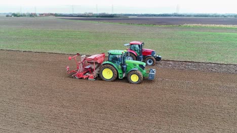two tractors working in a field sowing the next crop of wheat.