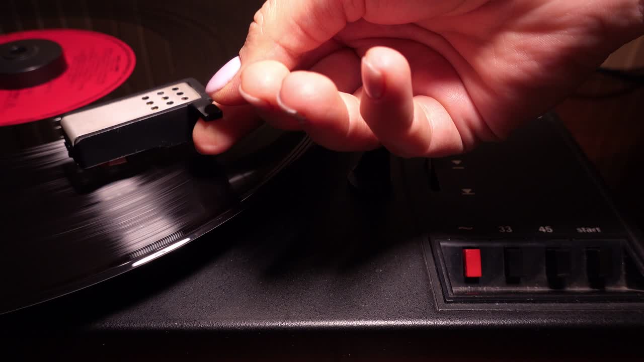 여성은 80 년대 dolly  클로즈업에서 레트로 바늘 회전 테이블에서 비닐 레코드를 재생합니다.