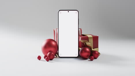 Vídeo-De-Regalos-De-Navidad,-Adornos-Y-Smartphone-Con-Espacio-Para-Copiar-Sobre-Fondo-Blanco.