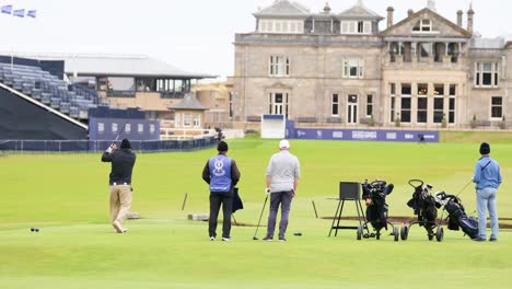 golfers practicing swings at historic st andrews course