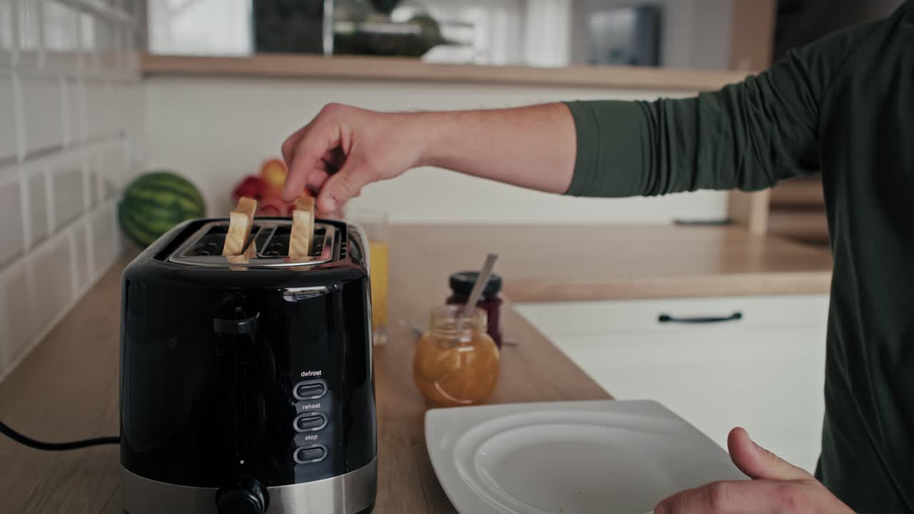 Caucasian adult caucasian man with down syndrome preparing toasts for breakfast.