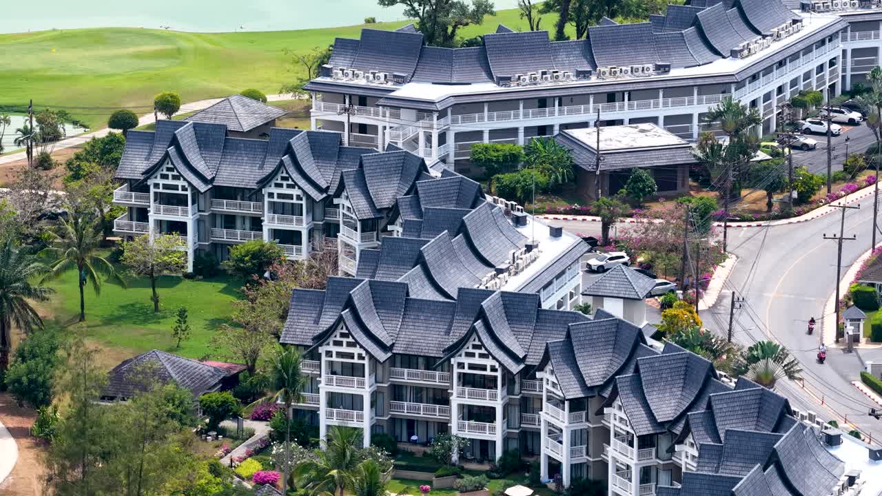 Ảnh flycam góc cao cho thấy các tòa nhà khu nghỉ dưỡng sang trọng, hồ bơi và một sân golf xanh mướt.