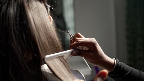 hairdresser straightening dark hair in slow motion