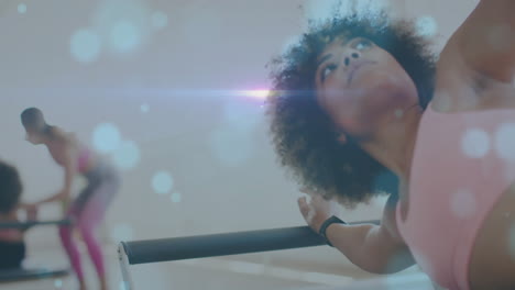 exercising in fitness studio, women with bokeh light animation in background