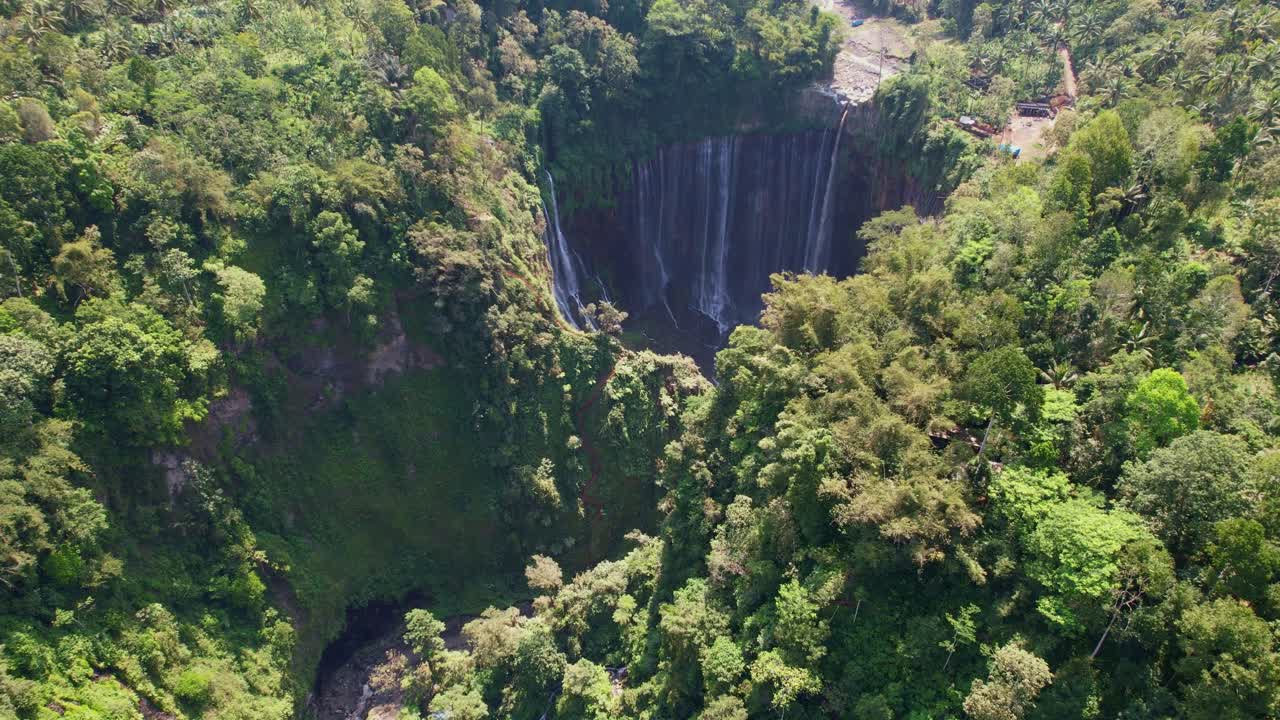 Lush greenery surrounds Tumpak Sewu waterfall near Semeru volcano