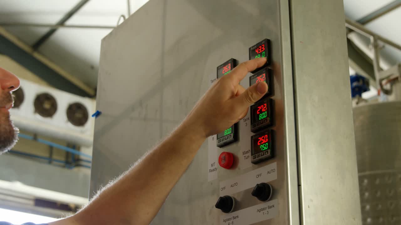 рабочий-мужчина, управляющий машиной на заводе 4k