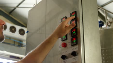 trabajador masculino que opera una máquina en una fábrica 4k