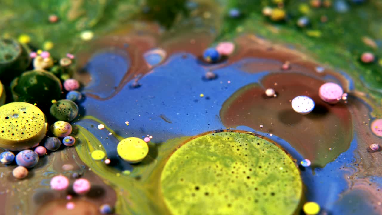 Abstrakte, farbenfrohe Blasen aus Acryl- und Lebensmittelfarbe auf Wasser