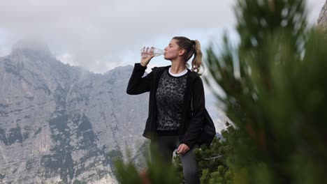 woman drinking water on mountains