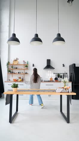 mujer bailando y disfrutando del desayuno en una cocina moderna