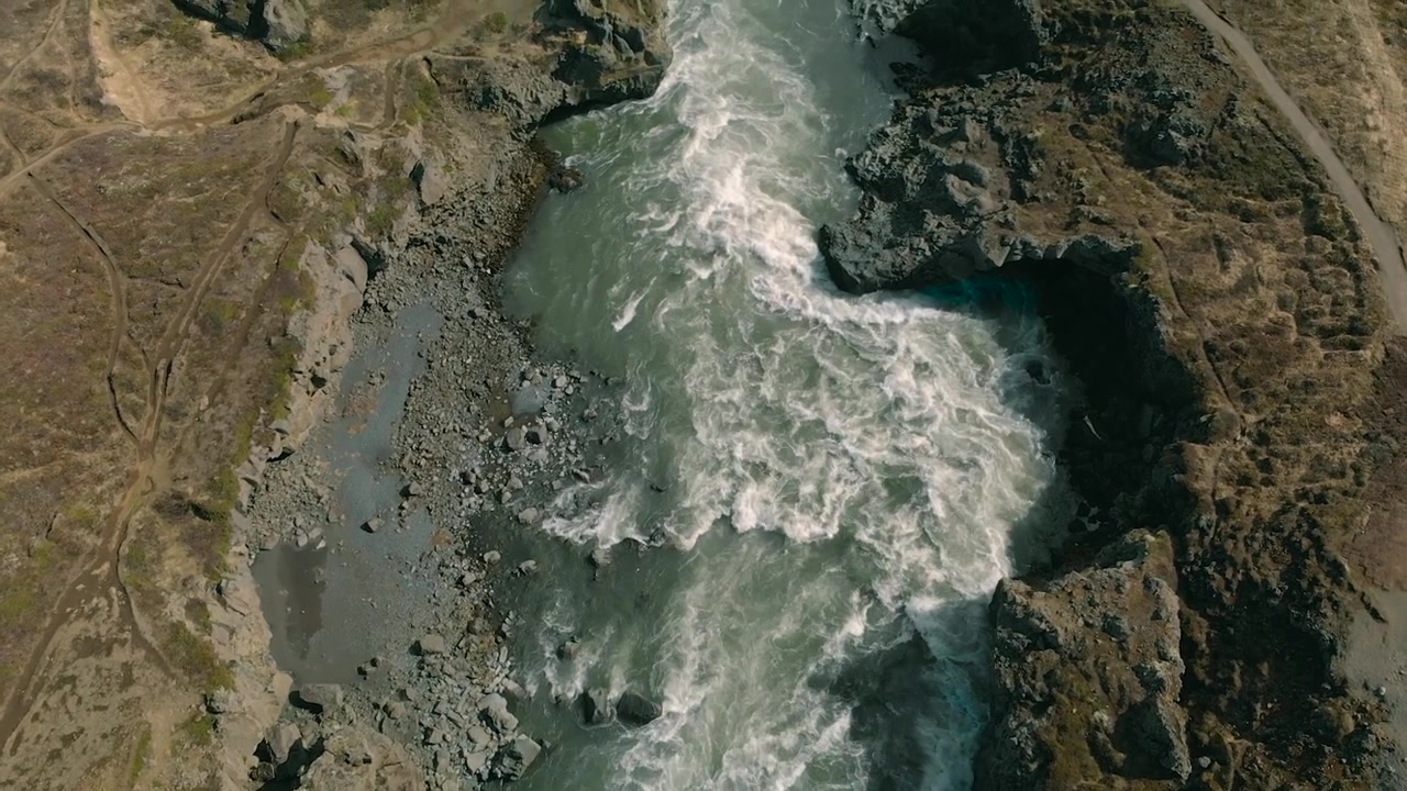 Vista aerea di potenti rapide fluviali che scorrono attraverso un canyon roccioso.