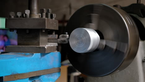 old lathe rotating and machining an aluminum piece medium shot