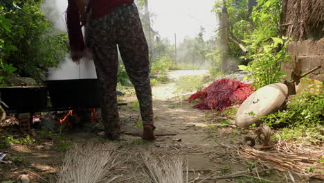 hombre teñido de pajuelas para alfombras y moquetas hechas a mano en una olla grande a fuego abierto