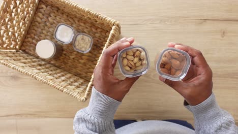 person holding containers of nuts