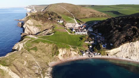 rückwärtsaufnahme aus der luft, die lulworth cove mit blick auf portland in der ferne zeigt