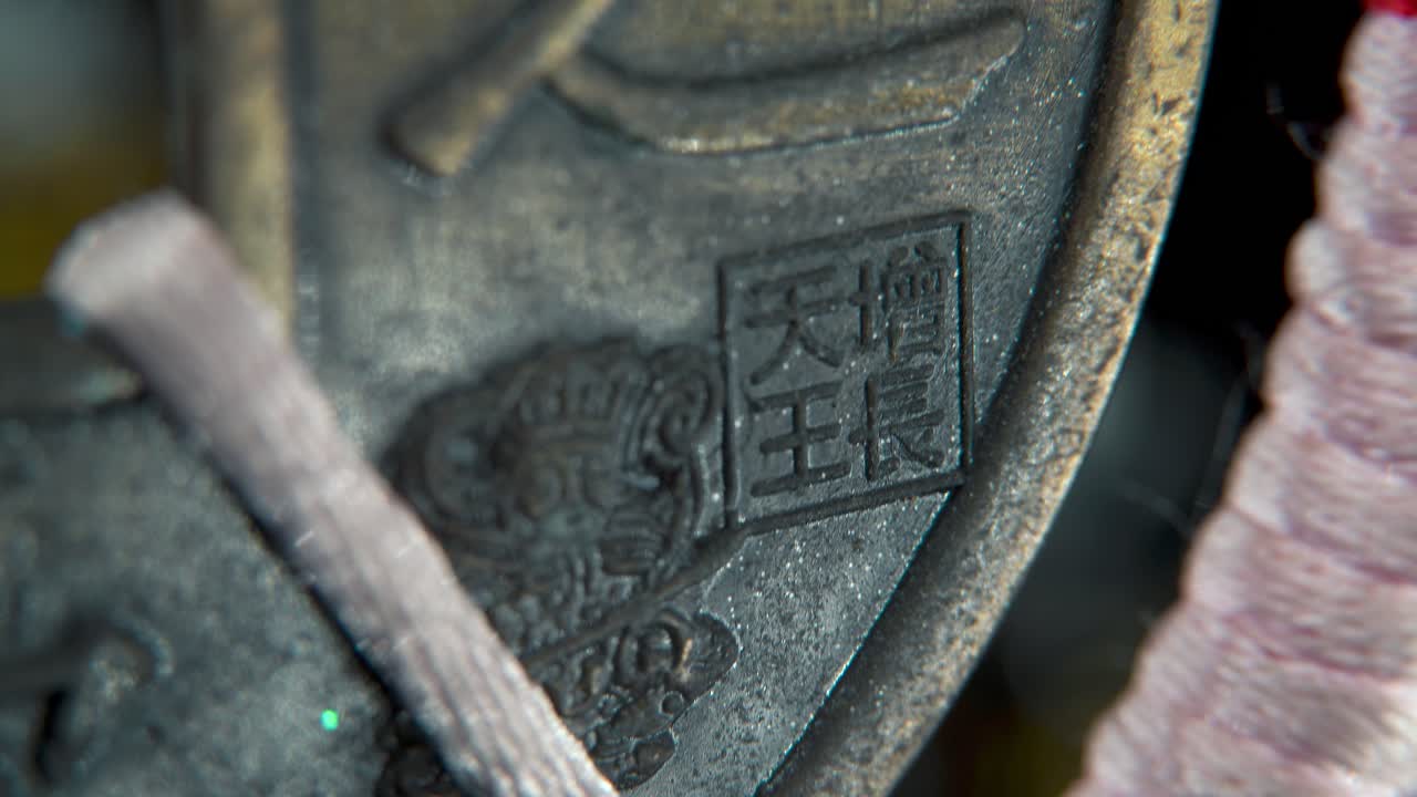 중국의 고대 전통 행운 동전, 아시아 새해 장식, 황금 반이는 흐릿한 배경, 사각형 구, 빨간 줄, 문화 축제 상징, 부드러운 기울기 4k 비디오