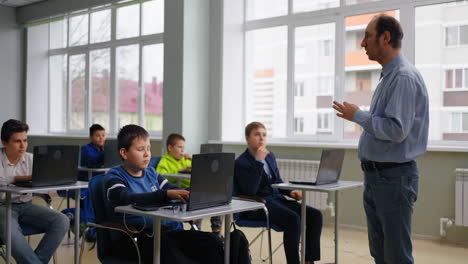 teacher instructing students in a computer lab