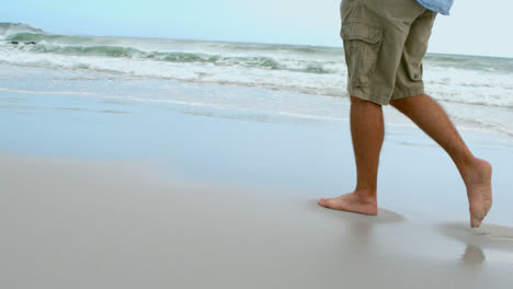 Unterer-Abschnitt-Eines-Barfüßigen-Mannes,-Der-Am-Strand-Läuft,-4k