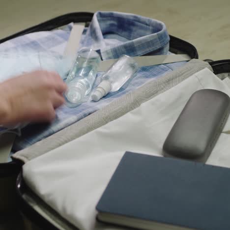 a woman packs clothes and face mask for a business trip 1