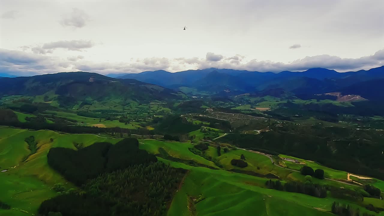 POV helicopter aerial flying over the rolling green hills of the Motueka valley near Abel Tasman