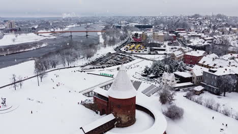 castillo de kaunas cubierto de nieve durante las nevadas, vista aérea ascendente