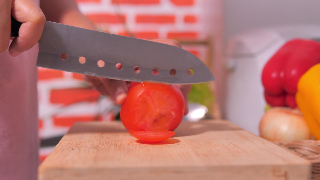 부의 절단판에 은 토마토를 칼로 손으로 잘라습니다.