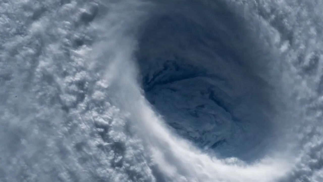 Satellitbillede af et massivt orkanøje fra rummet. Kæmpe tropisk cyklon, tyfon eller tornadostorm, der hvirvler med tætte hvide skyer i atmosfæren.
