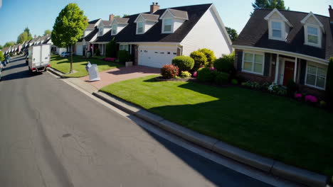 man delivers a package to a suburban home