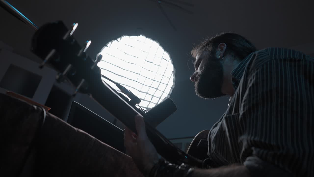 Man playing guitar in a home studio