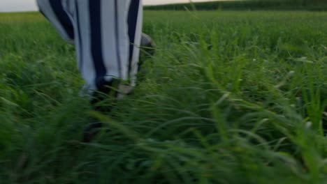 woman walking in a striped outfit through a field