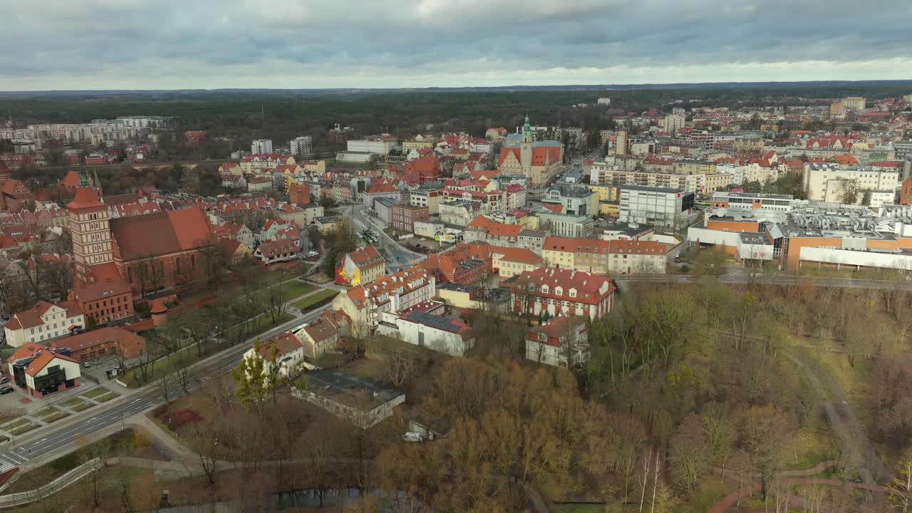 Captivating aerial perspective of Olsztyn's city center, showcasing the blend of Gothic architecture and modern urban landscapes against a dramatic cloudy sky in northern Poland
