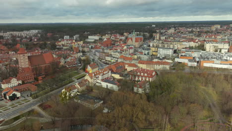 Cautivadora-Perspectiva-Aérea-Del-Centro-De-La-Ciudad-De-Olsztyn,-Que-Muestra-La-Combinación-De-Arquitectura-Gótica-Y-Paisajes-Urbanos-Modernos-Contra-Un-Espectacular-Cielo-Nublado-En-El-Norte-De-Polonia