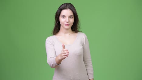 young happy beautiful woman smiling while giving thumbs up