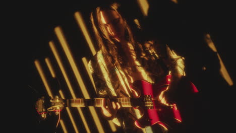 young indie musician playing electric guitar in projected light