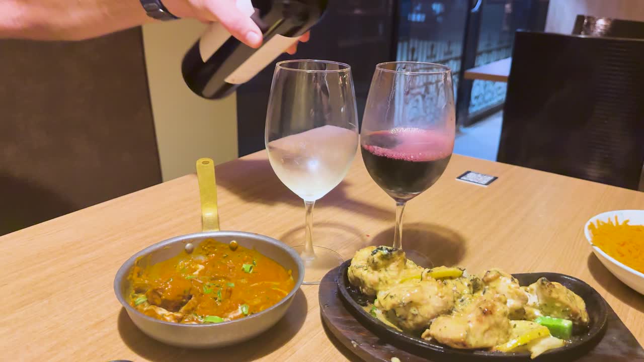 vino servido junto al plato de curry indio humeante