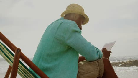 side view of african american man using digital tablet on the beach 4k