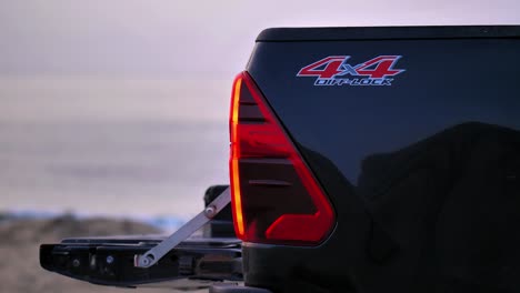 View-Of-Back-Of-4x4-Pick-Up-Truck-With-Red-Tail-Lights-And-Decals