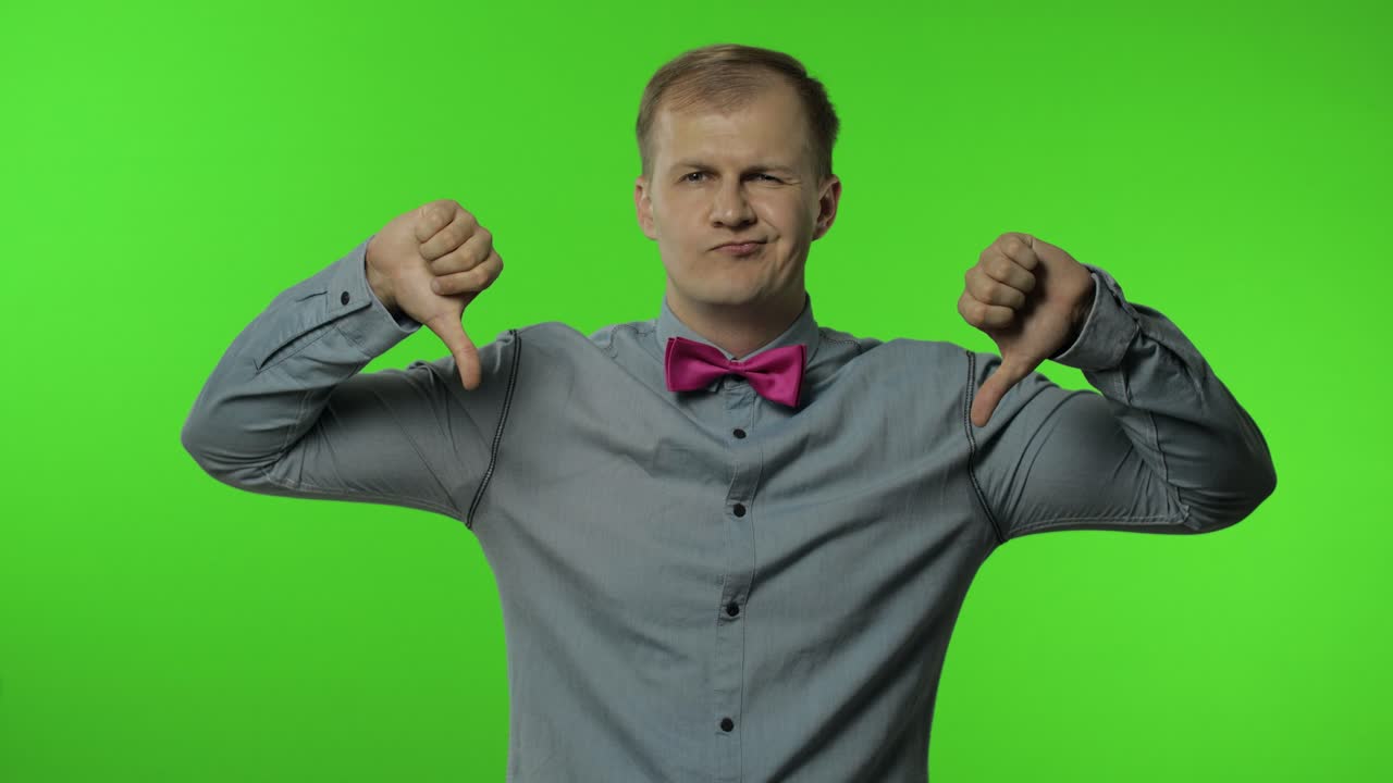 hombre molesto mostrando pulgares dobles hacia abajo, diciendo no, no me gusta y rechazando mala elección, disgusto gesto