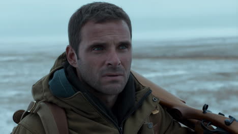 man with a rifle in a cold winter landscape
