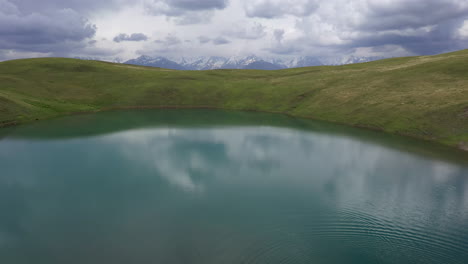 Tiro-De-Drone-De-Un-Hombre-Caminando-Cerca-Del-Lago-Oreit-En-Tusheti-Georgia,-En-Las-Montañas-Del-Cáucaso