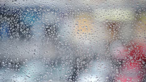 transparent raindrops on glass or window, droplets after heavy thunderstorm on blurred street traffic background. feeling of loneliness, sadness and depression, wallpaper pattern of water drops on