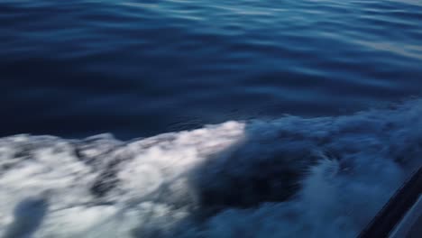 gimbal close-up shot of the fast-flowing undertow wake from a small charter boat moving on the ocean