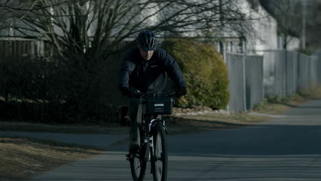 a man rides a bicycle on a residential street