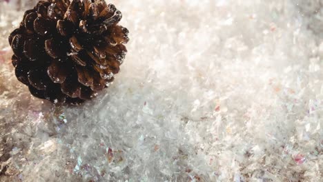 animation of falling snow over pine cone