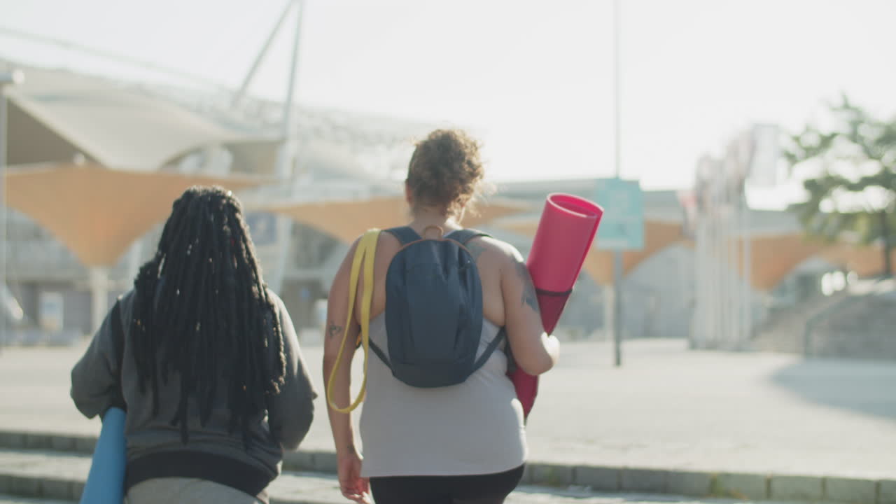 vista trasera de mujeres gordas subiendo escaleras al estadio deportivo