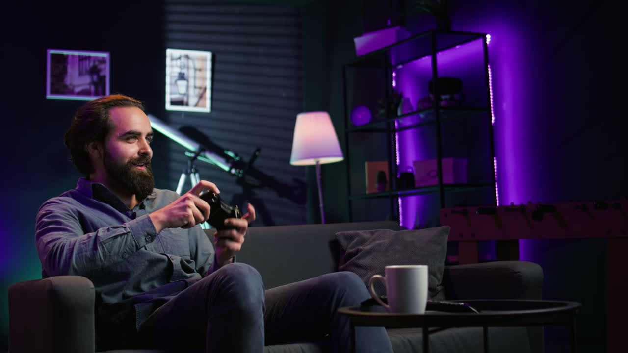 컨트롤러를 들고 네온 조명 방에서 비디오 게임을 즐기는 남자