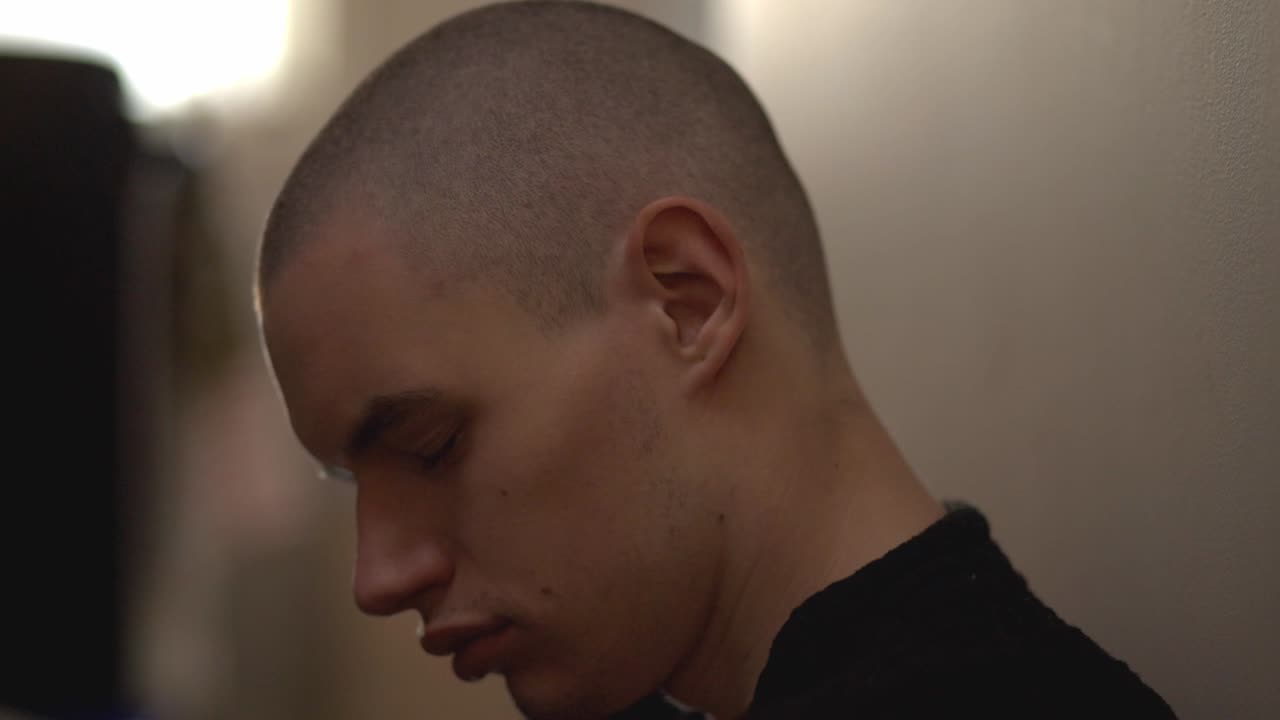 불투명한 배경에 고립된 채 혼자 앉아 있는 우울한 청년 - 클로즈업 샷